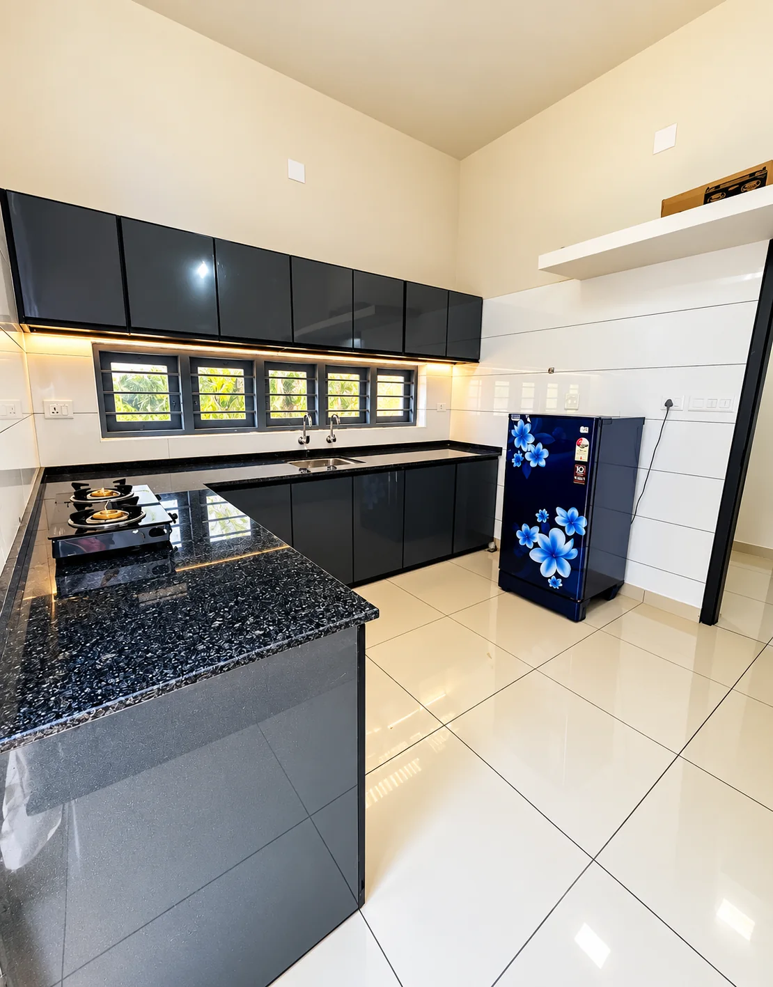 A kitchen with black cabinetry and a tiled floor